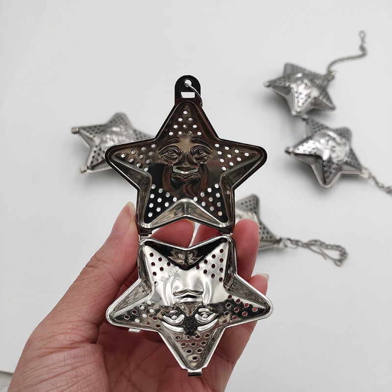 a hand holding a star shaped tea strainer
