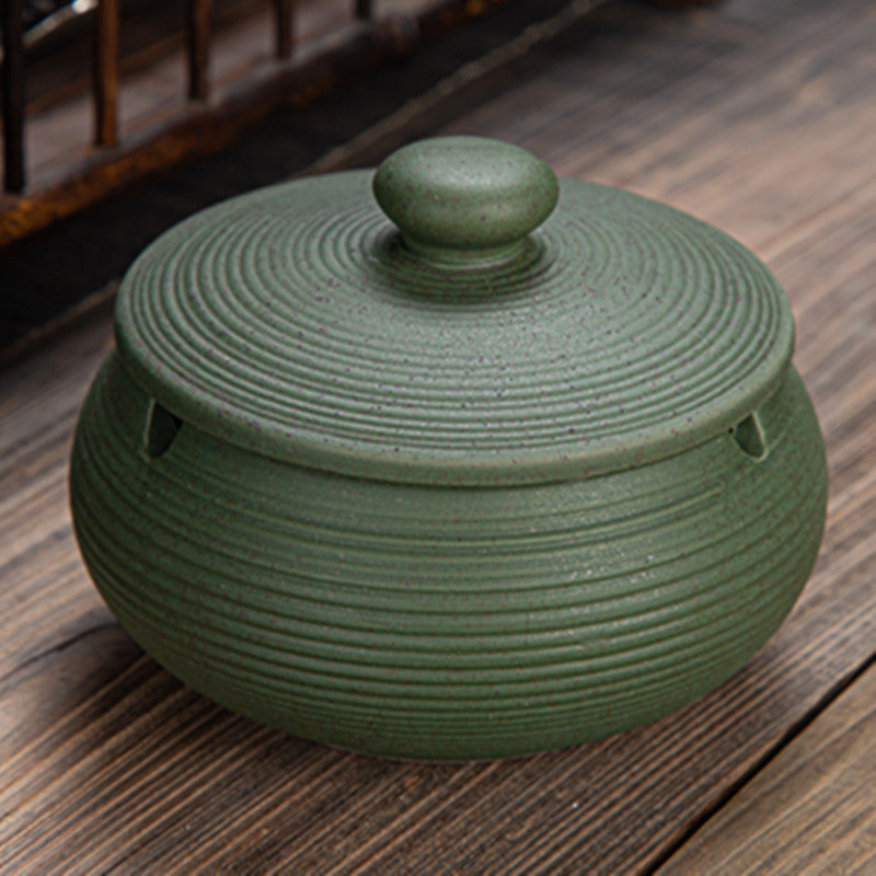 a green ceramic pot with a lid