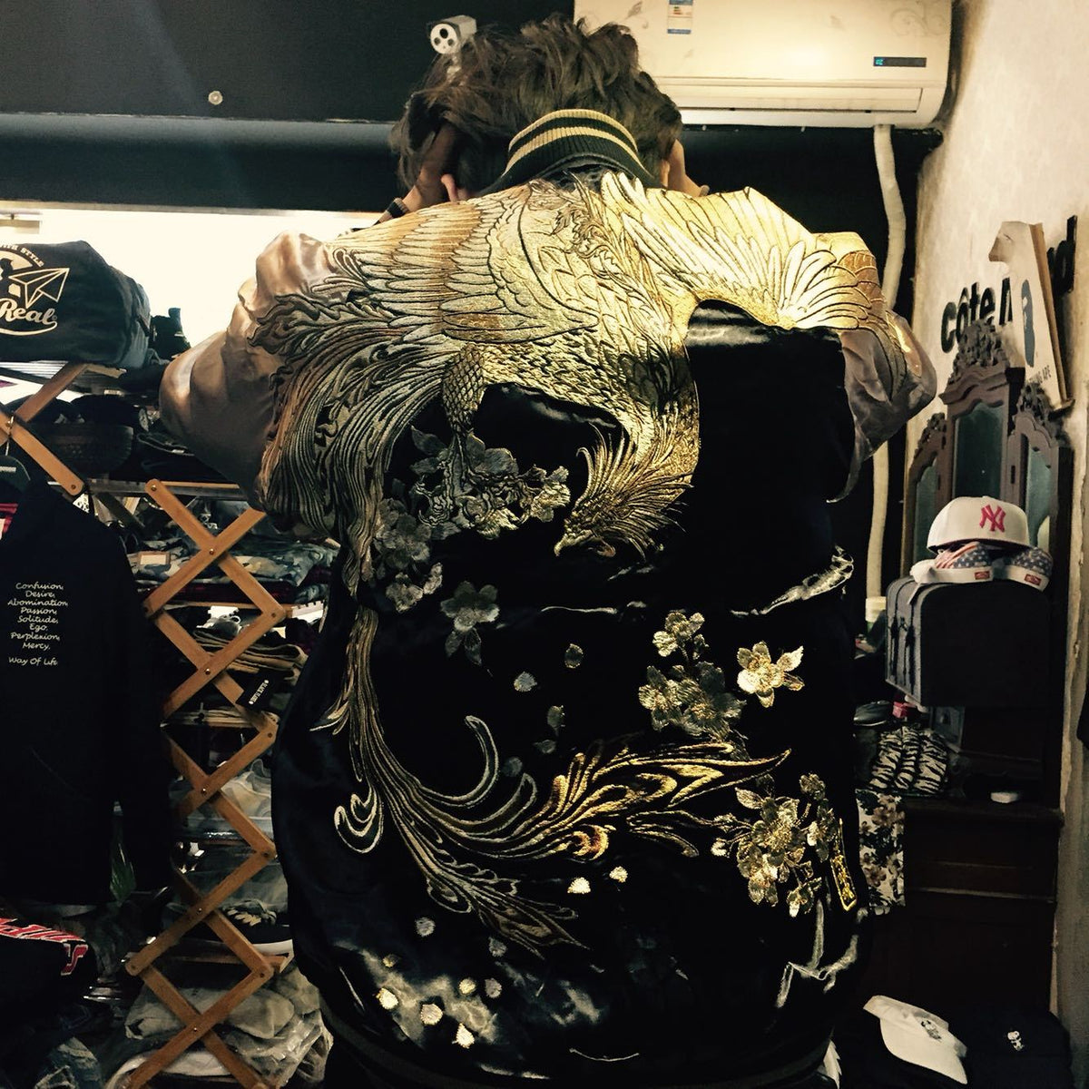 a person in a black jacket with gold designs