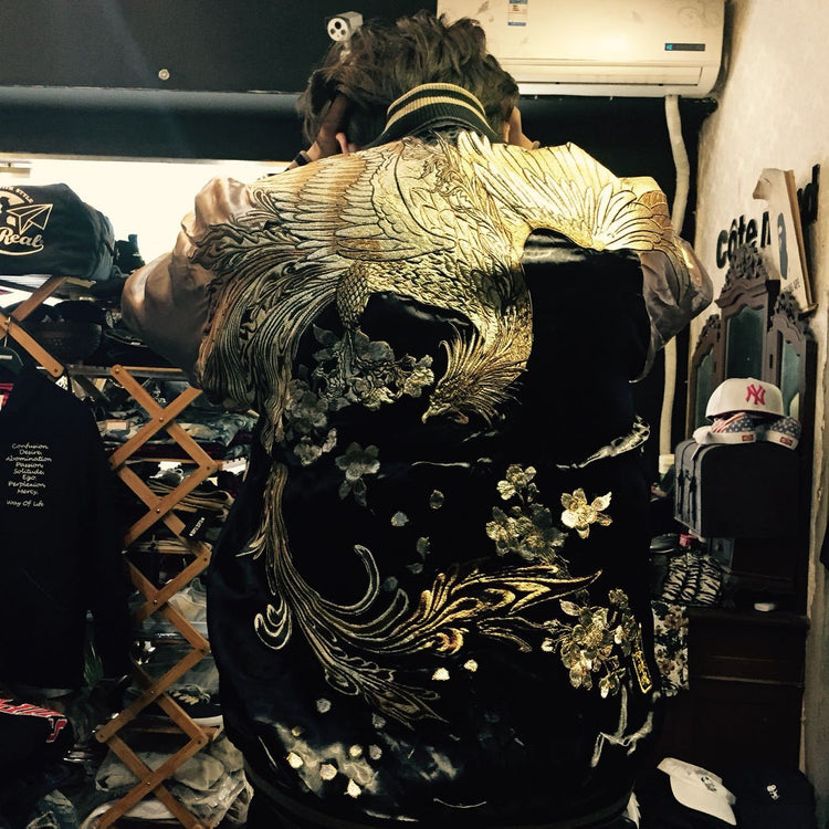a person in a black jacket with gold designs