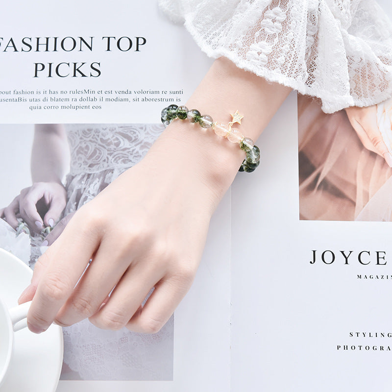 a hand with a bracelet on a magazine