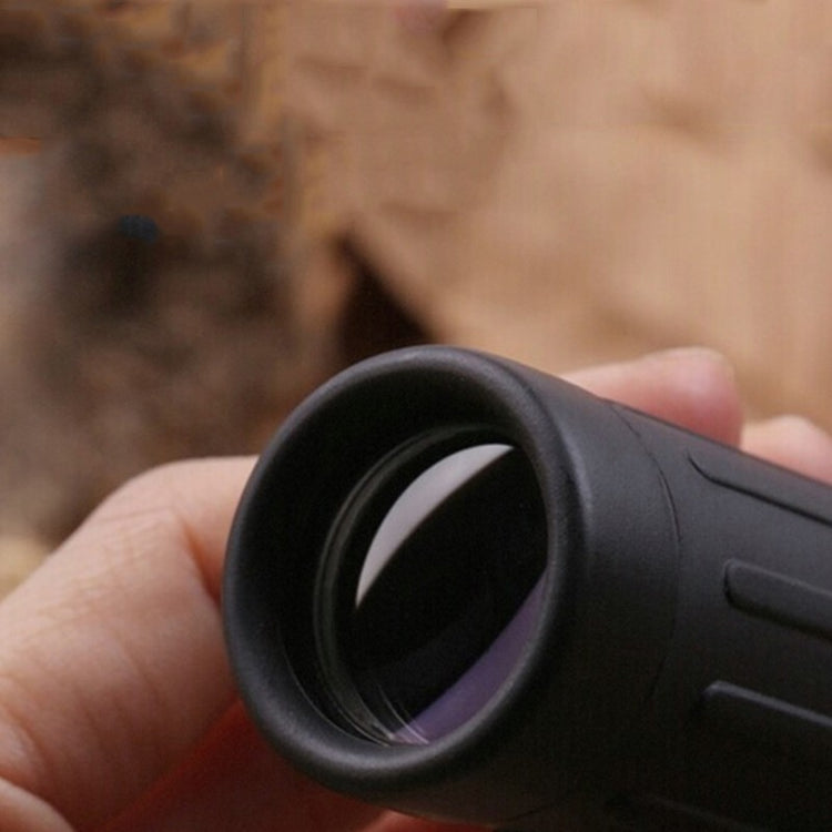 a hand holding a black telescope