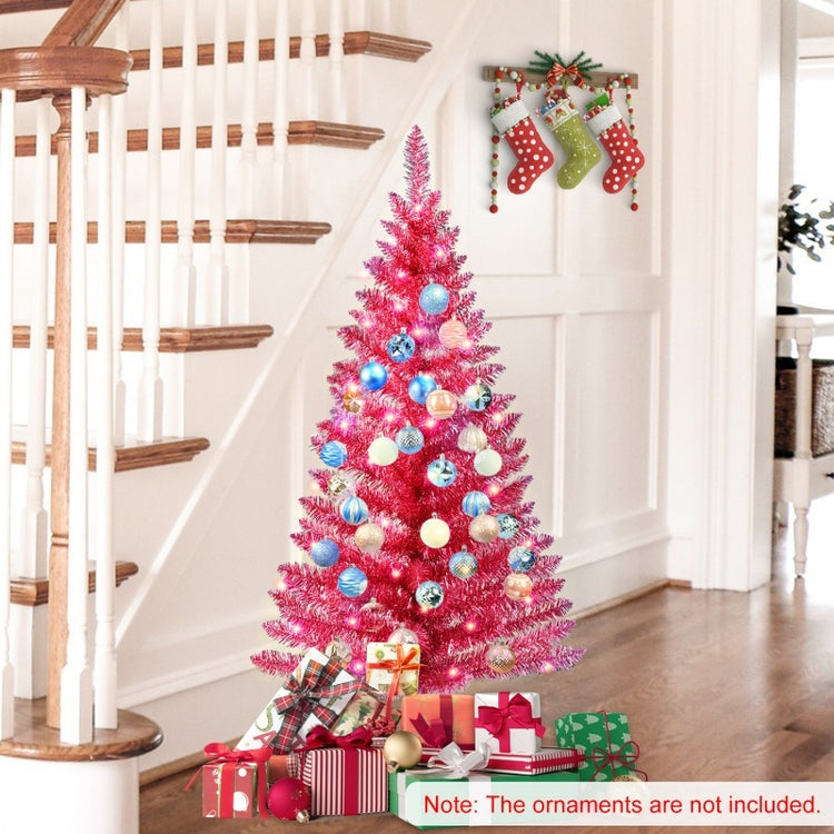 a pink christmas tree with ornaments and presents on the stairs