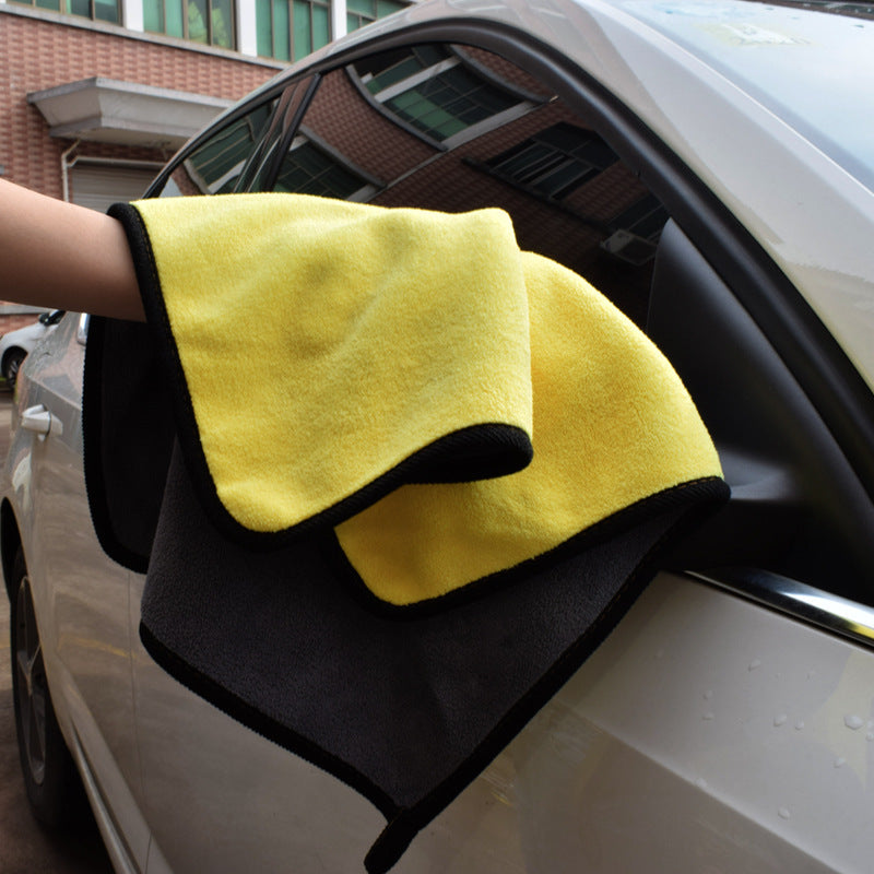 a hand holding a yellow and black towel