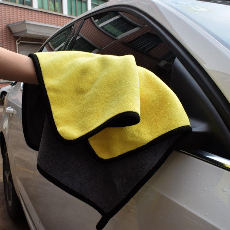 a hand holding a yellow and black towel