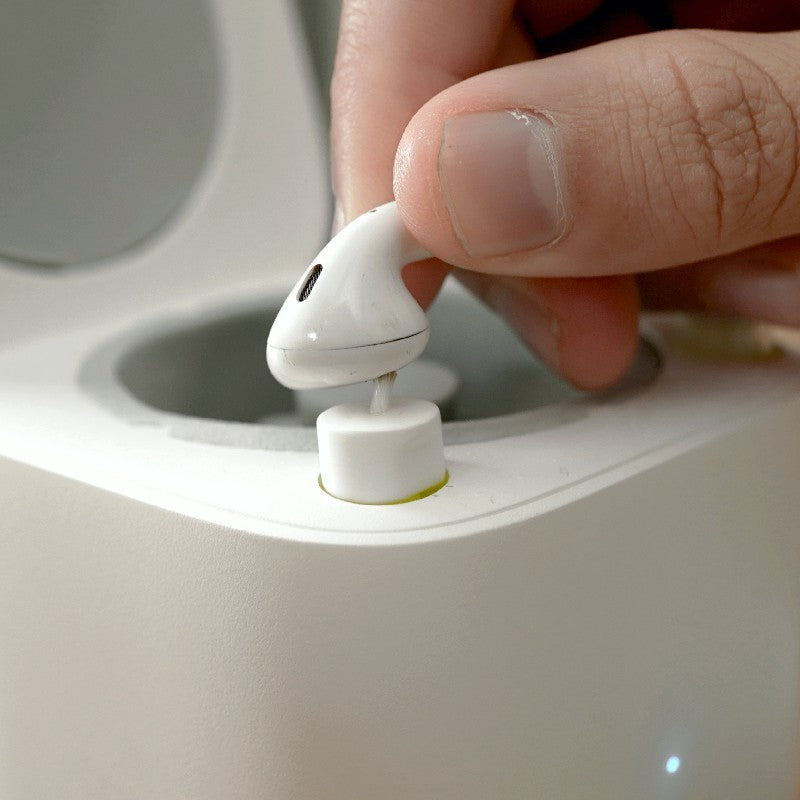a person holding a white earbud