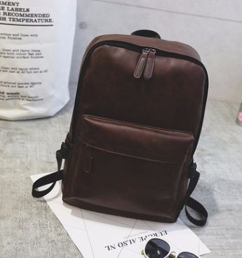 a brown backpack on a white surface