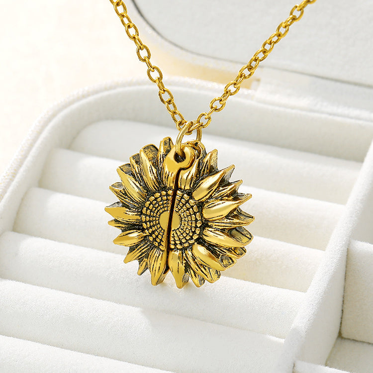 a gold sunflower necklace in a jewelry box