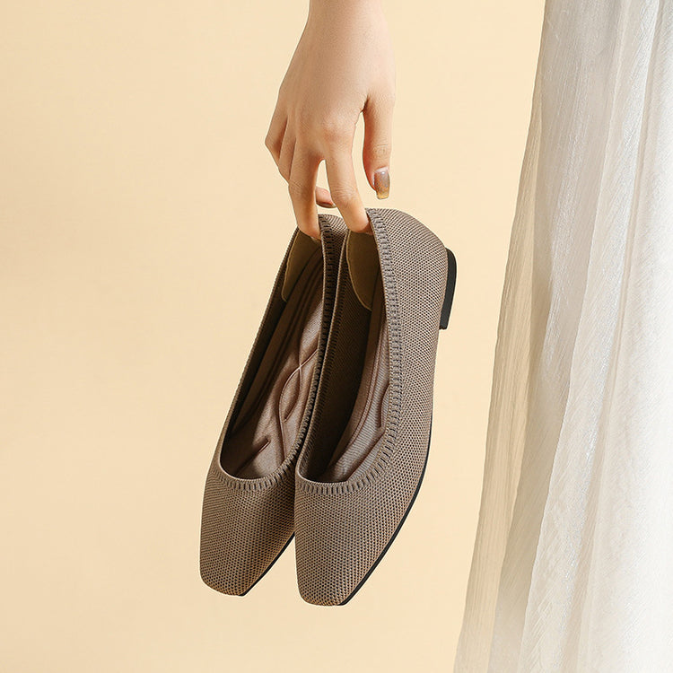 a hand holding a pair of shoes