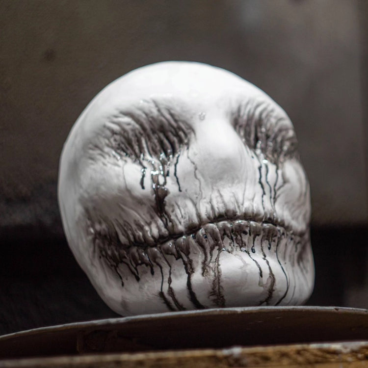 a white skull with black paint on it