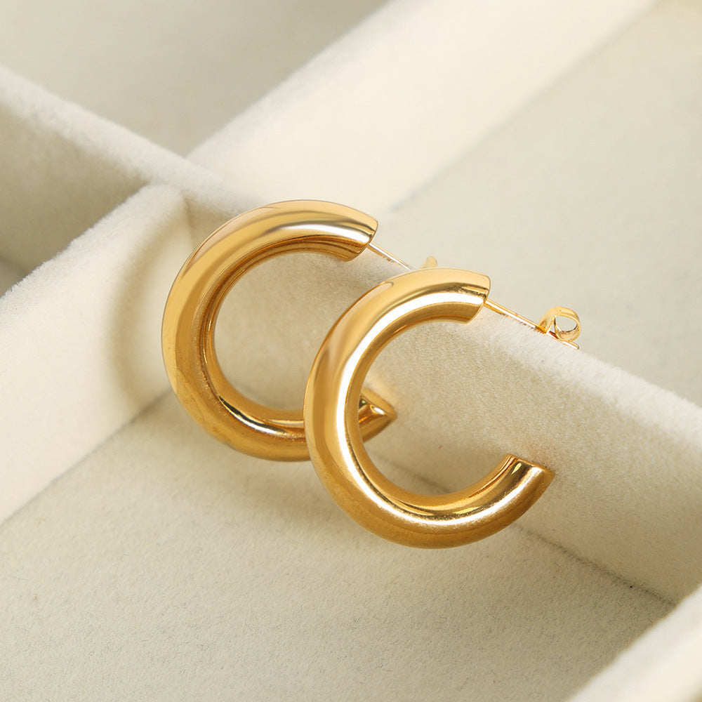 a pair of gold hoop earrings in a jewelry box
