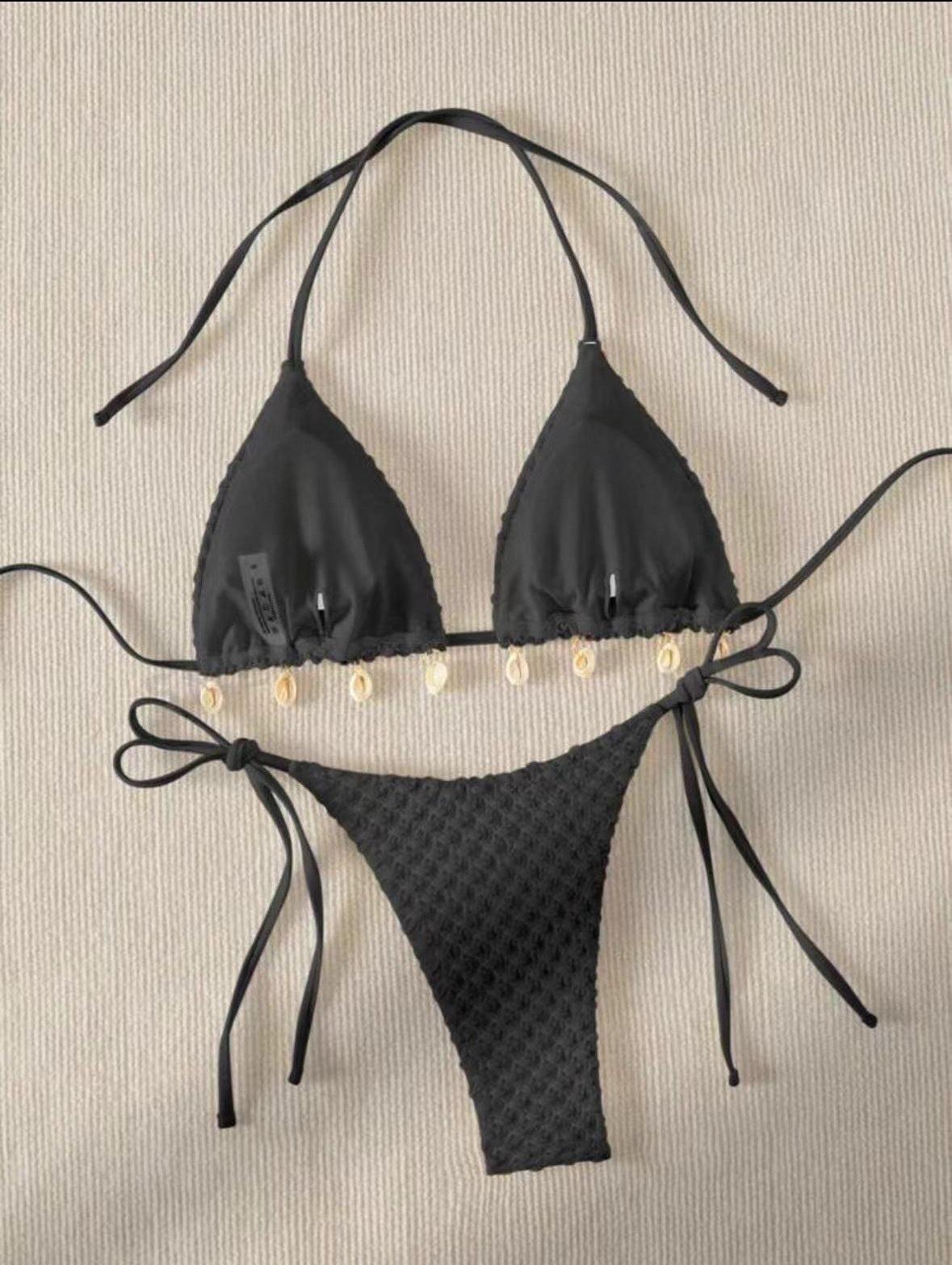 a black garment with white shells on it