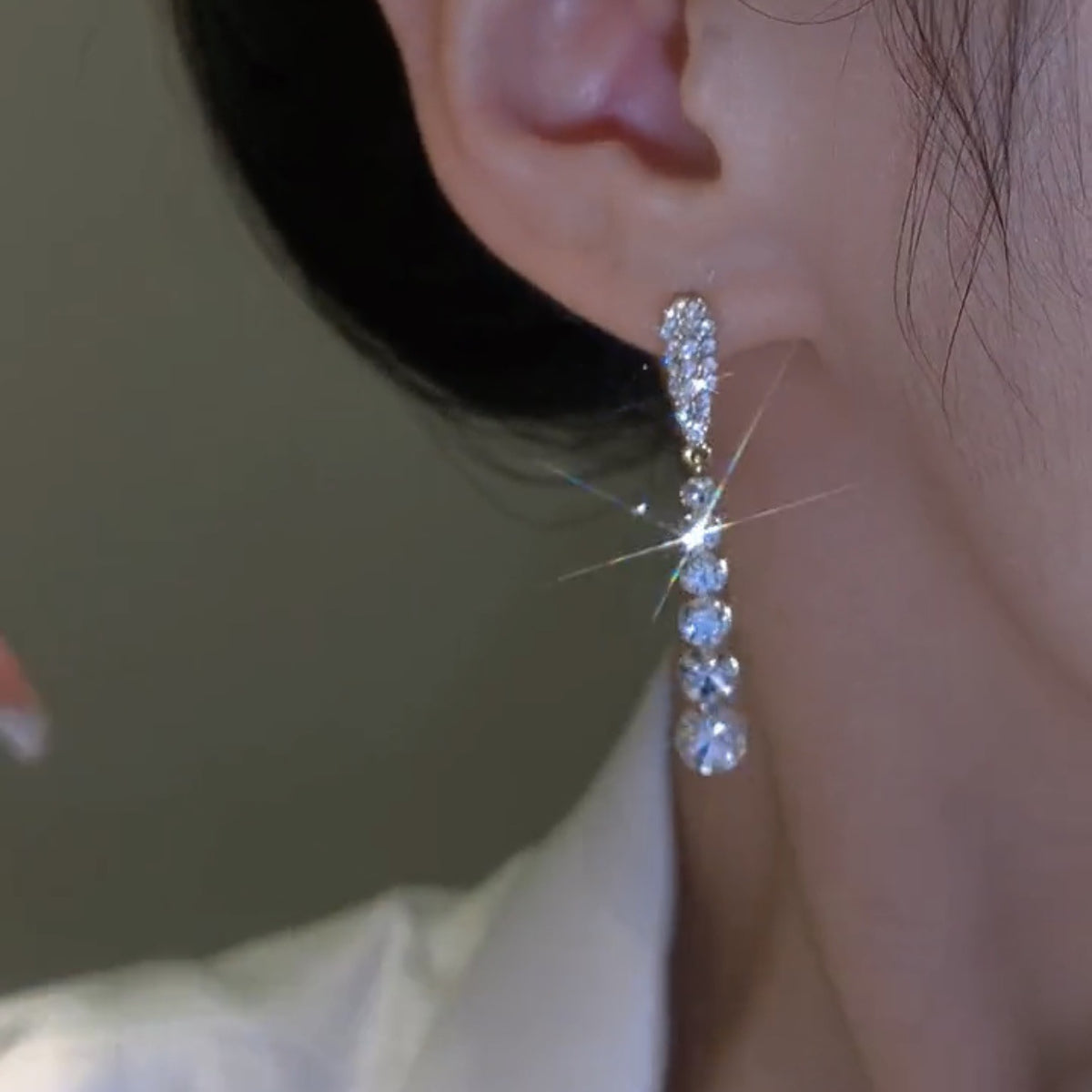 a woman wearing a diamond earring