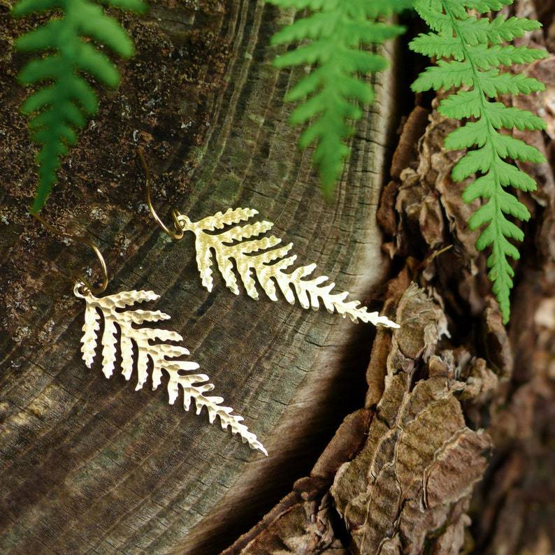 a pair of earrings on a tree stump