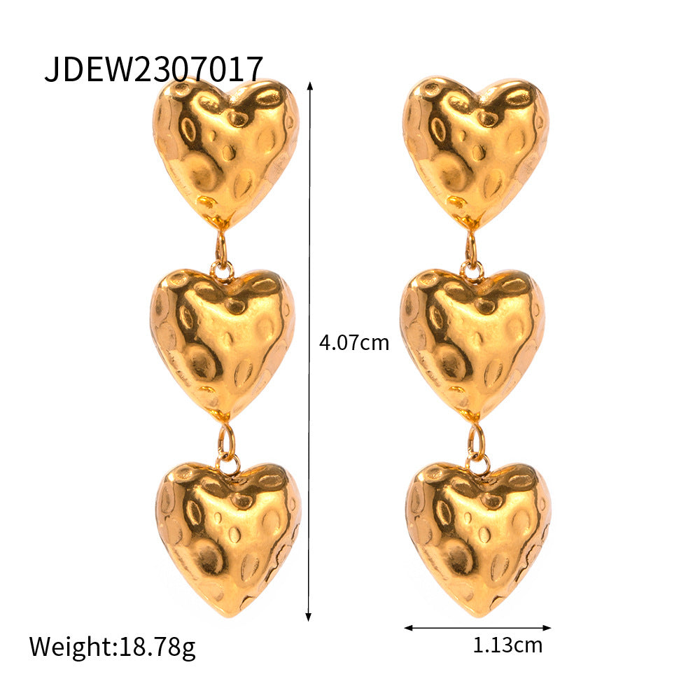 a pair of gold heart earrings