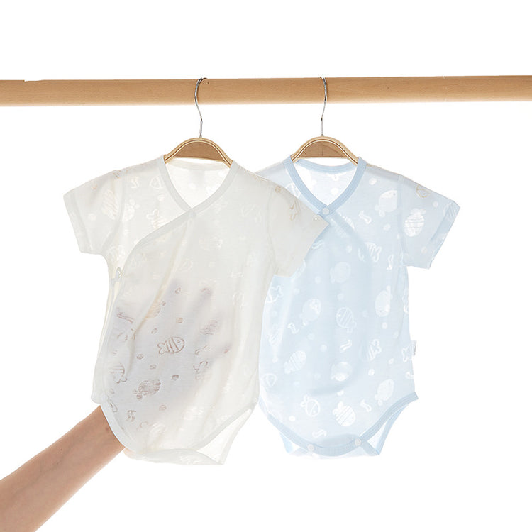 a hand holding a pair of baby clothes