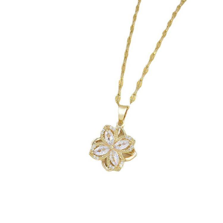 a gold necklace with a flower pendant