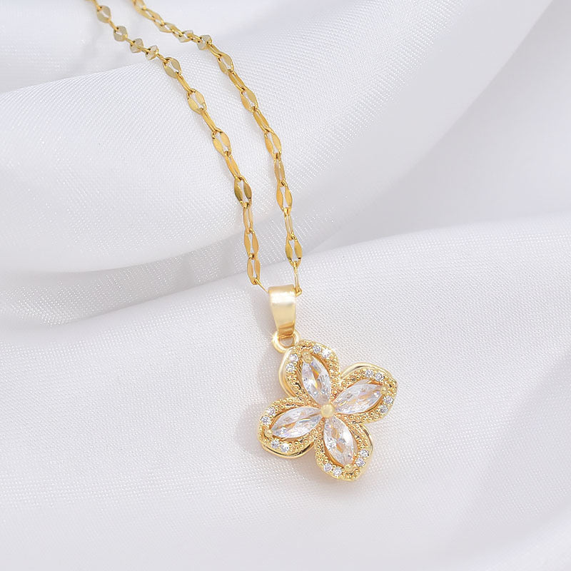 a gold necklace with a flower pendant