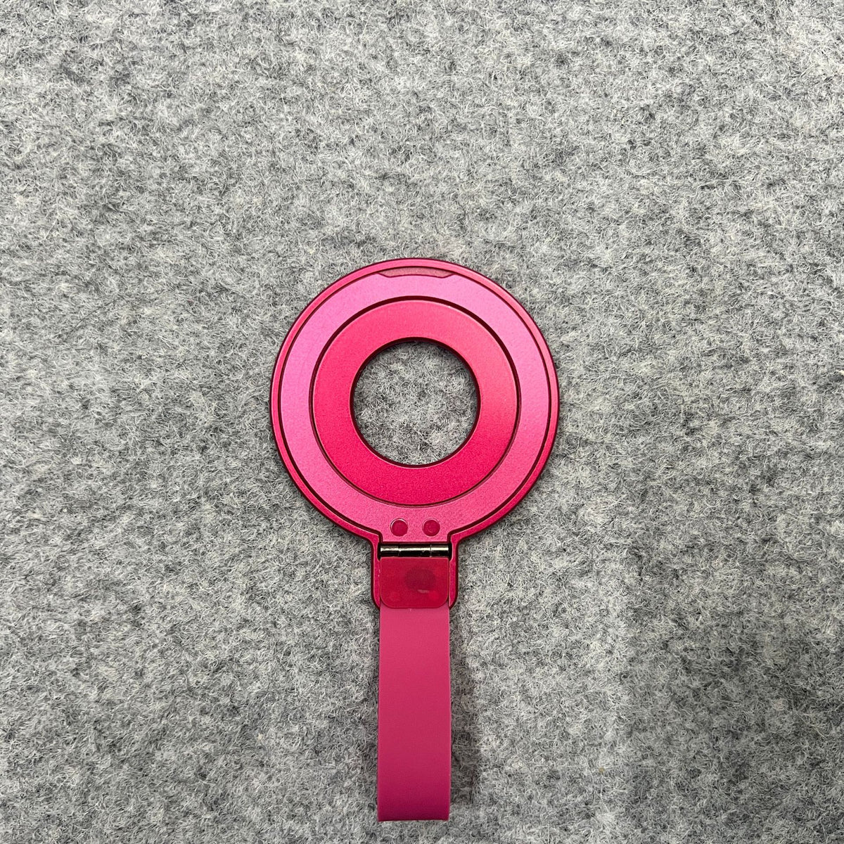 a pink circular object with a strap