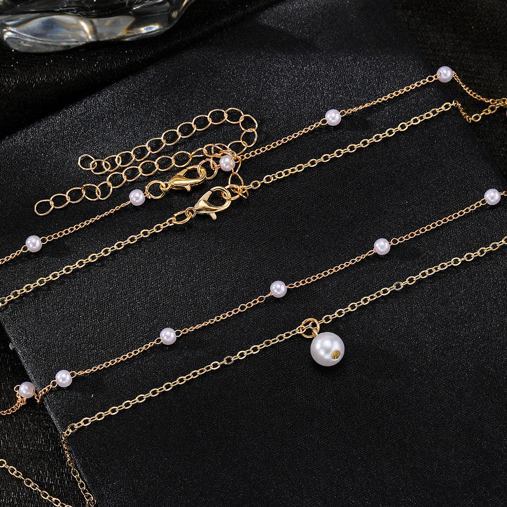 a gold chain with pearls on it