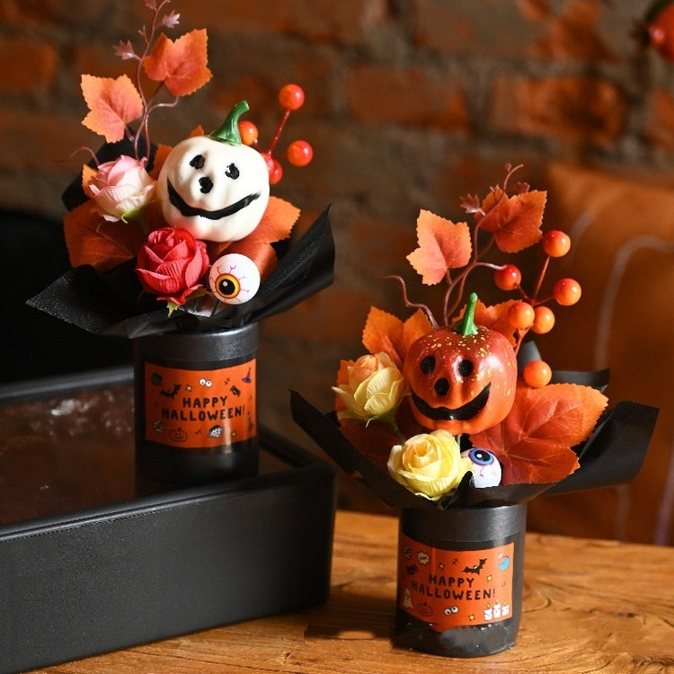 two small black containers with flowers and pumpkins