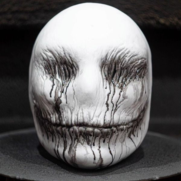 a white mask with black paint on it