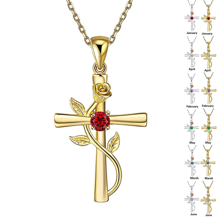 a gold cross with a red stone and a rose on a chain