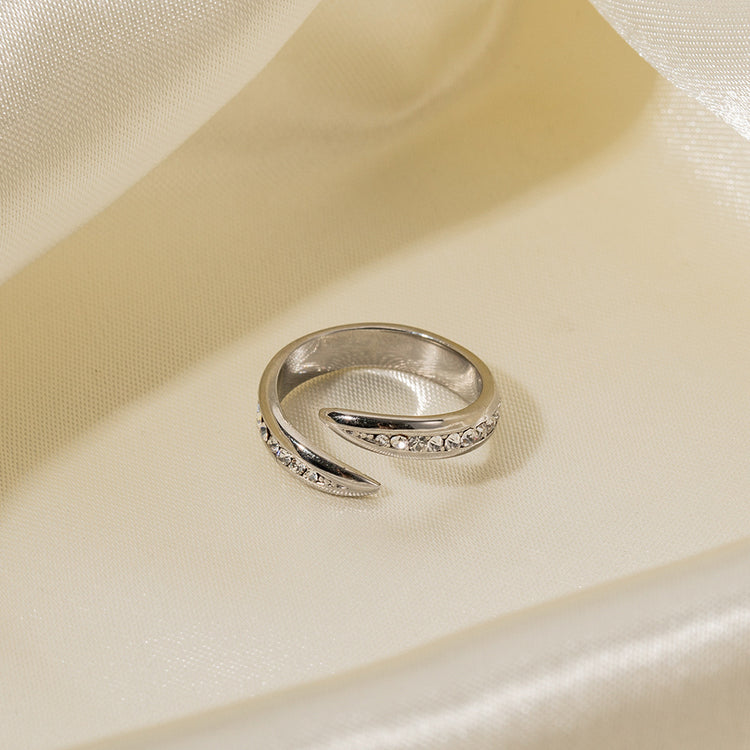 a silver ring with diamonds on a white fabric