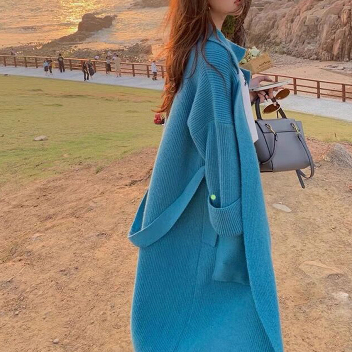 a woman in a long blue coat