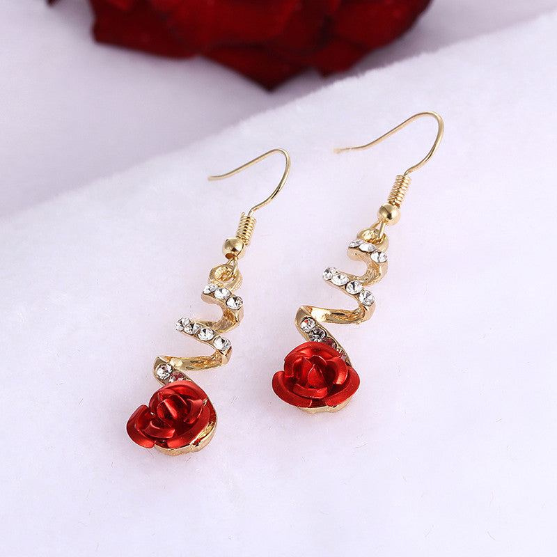 a pair of earrings with red flowers