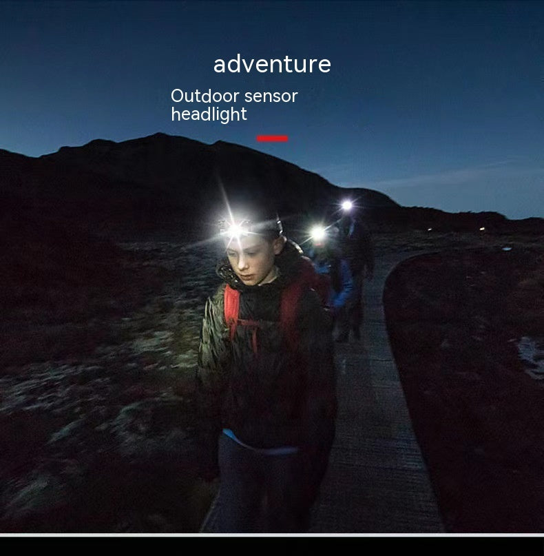 a group of people with headlamps on a path