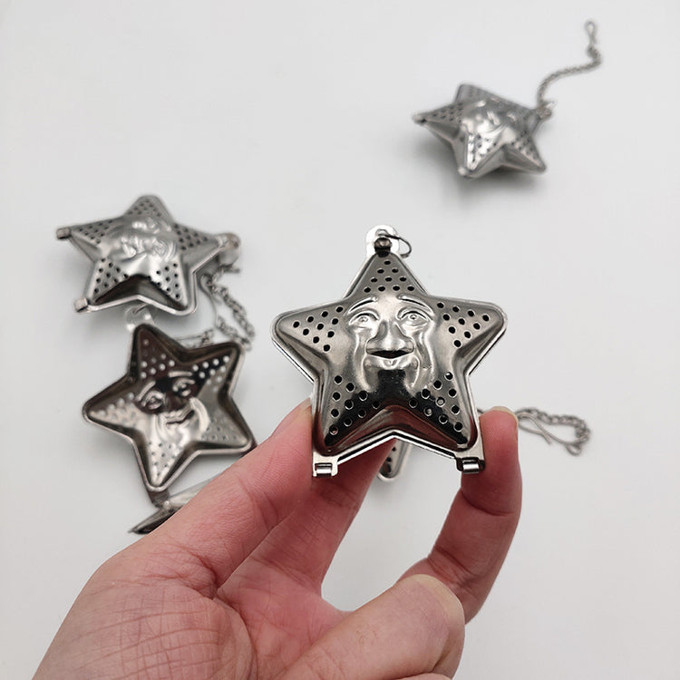 a hand holding a star shaped tea strainer