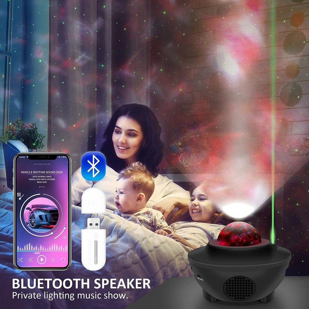 a woman and a baby in bed with a bluetooth speaker