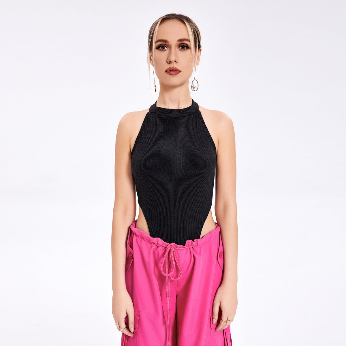 a woman in a black top and pink pants