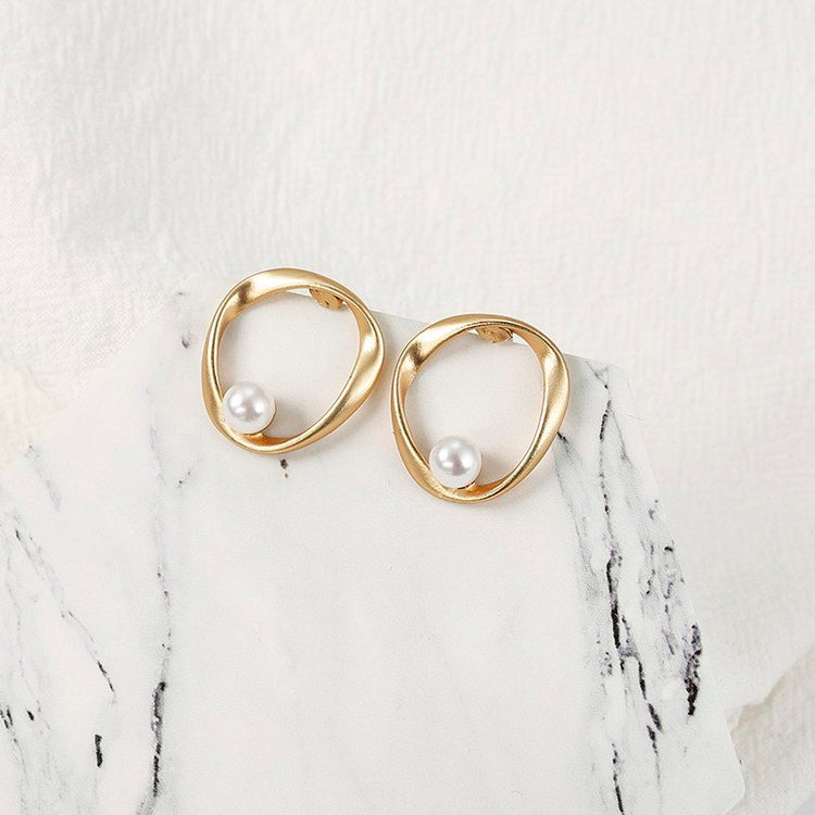 a pair of gold earrings with pearls
