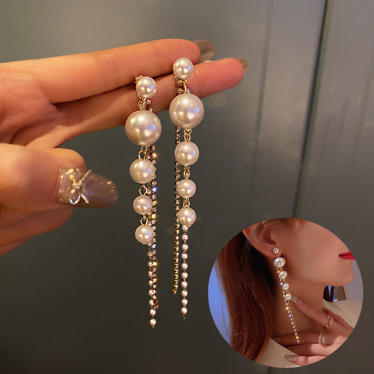 a person holding a pair of earrings