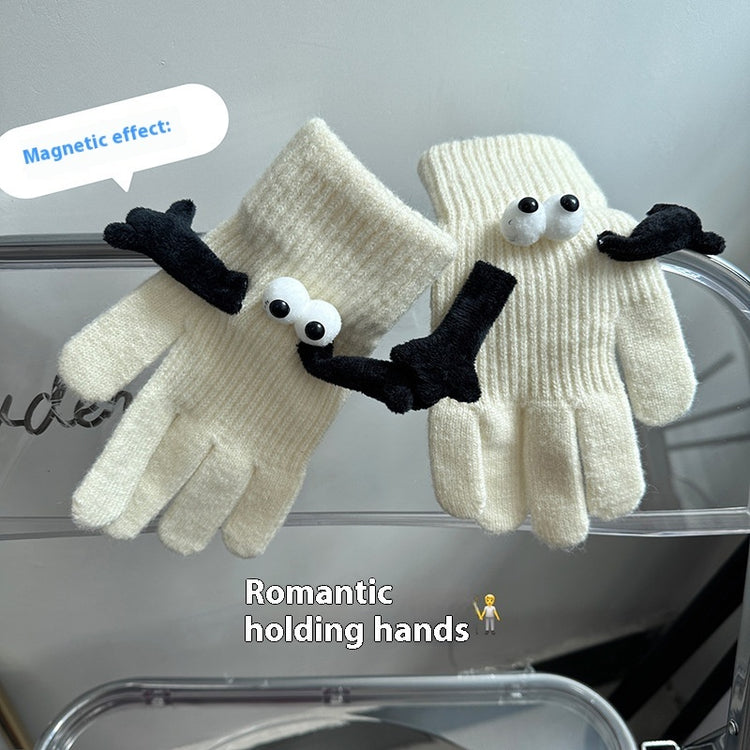 a pair of white gloves with eyes and a black glove on a shelf