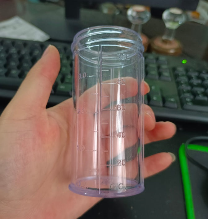 a hand holding a plastic cylinder