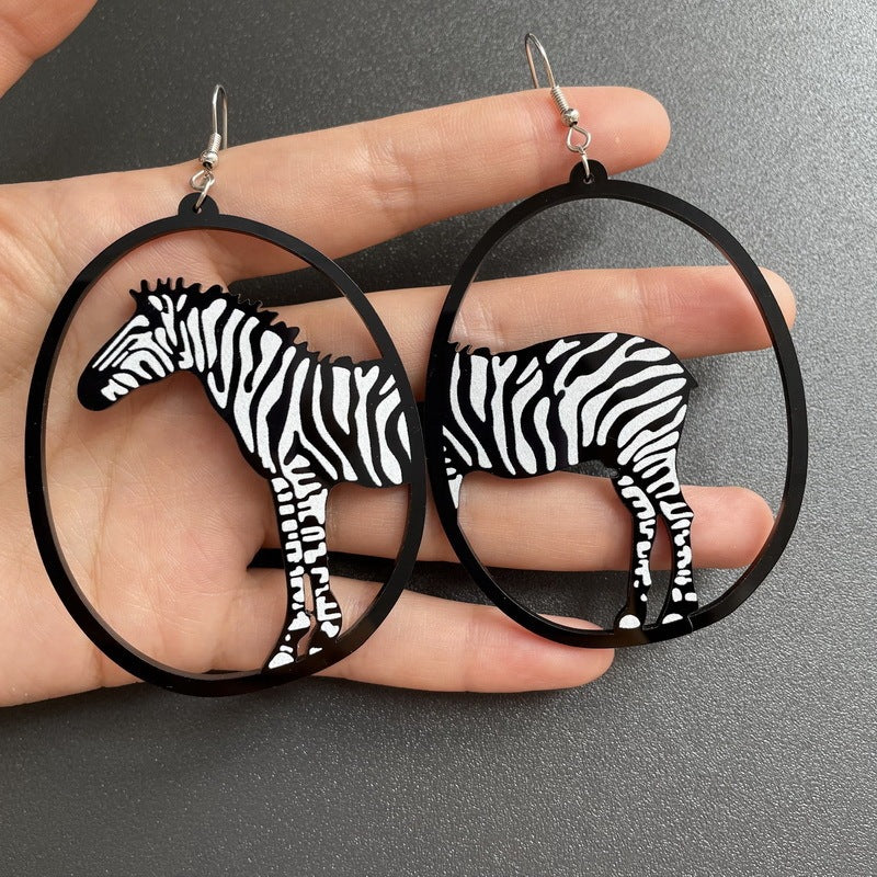 a hand holding a pair of earrings