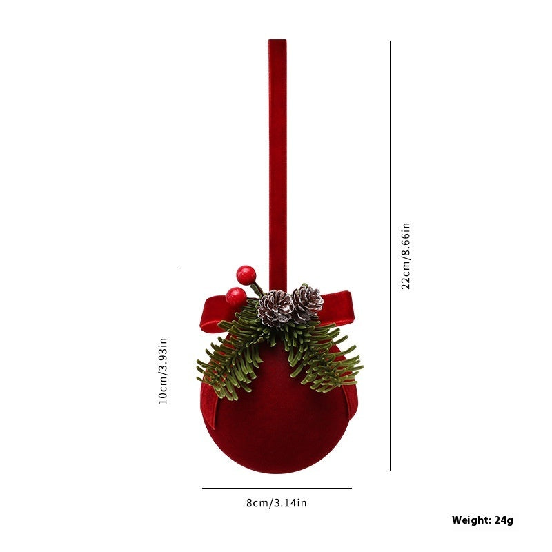 a red christmas ornament with a ribbon and pinecones