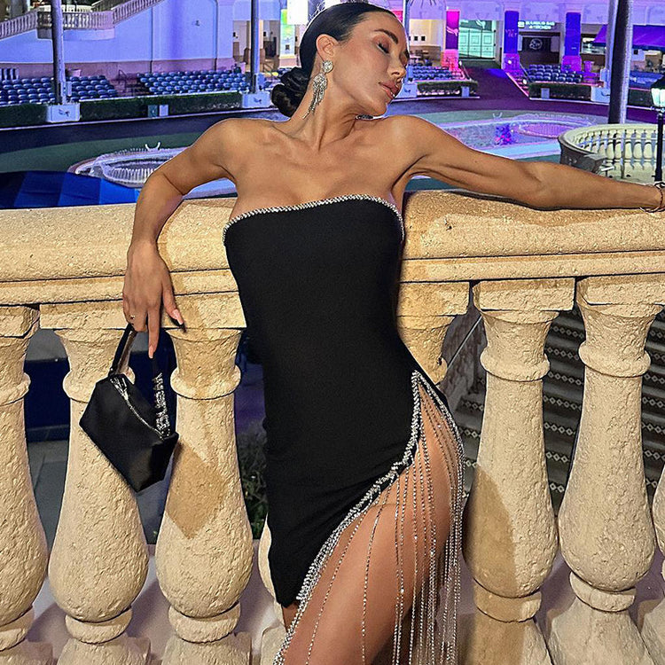 a woman in a black dress leaning on a stone railing