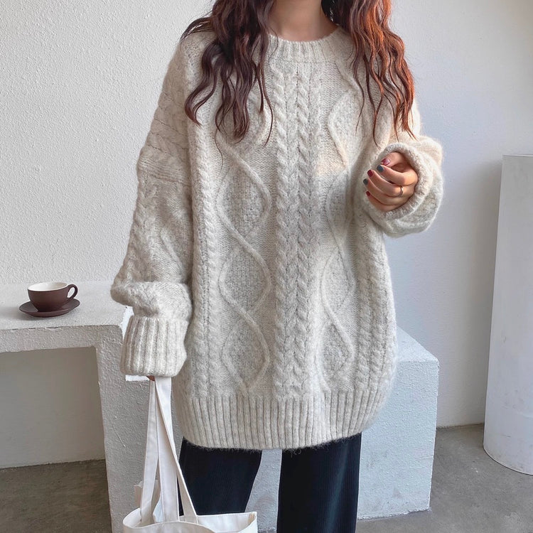 a woman wearing a sweater and a white bag
