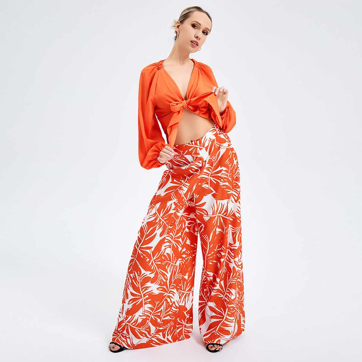 a woman in orange shirt and white pants