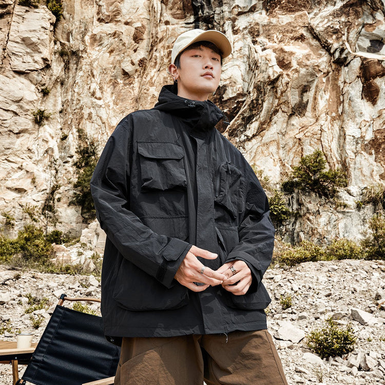 a man standing in front of a rock wall