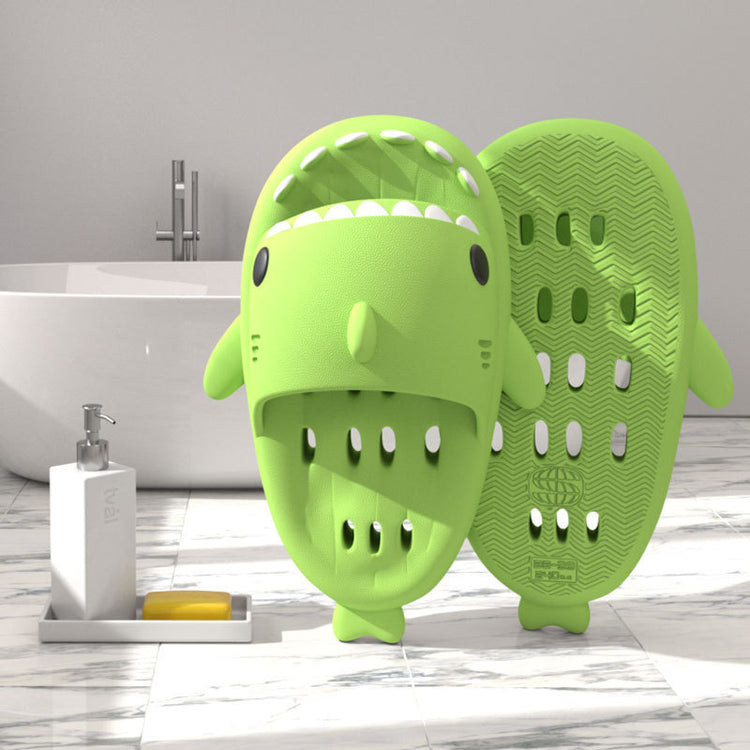 a green animal shaped object next to a white bathtub