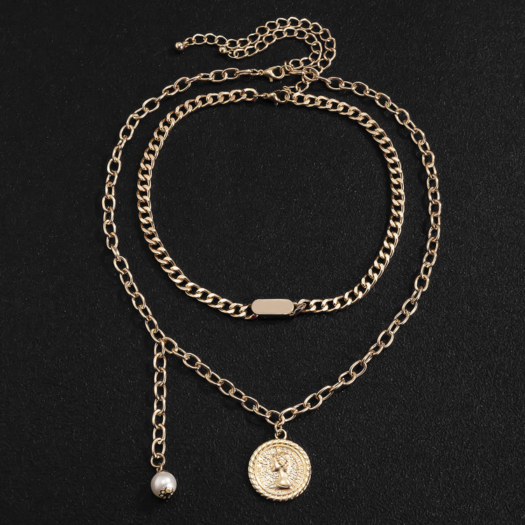 a gold chain necklace with a coin and a pearl necklace