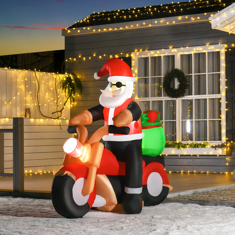 a inflatable santa claus on a motorcycle in front of a house