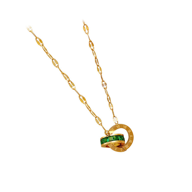 a gold necklace with a green stone in the middle
