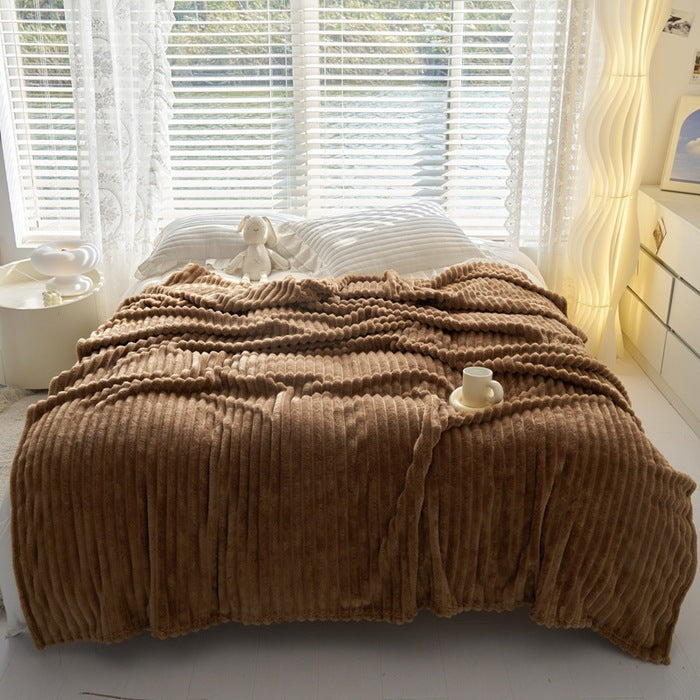 a bed with a blanket and a stuffed animal