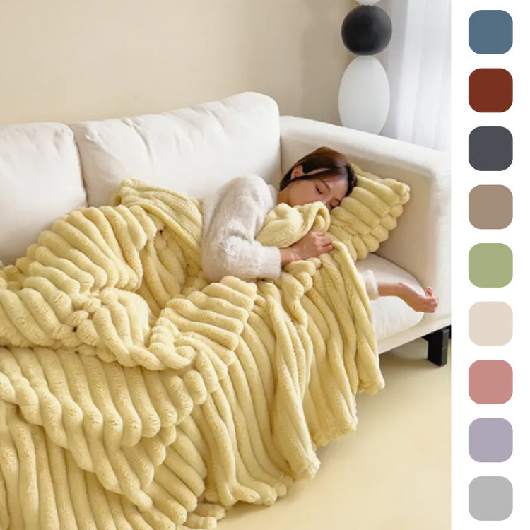 a woman sleeping on a couch covered in a blanket